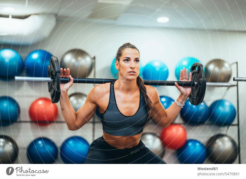Frau trainiert mit Gewicht in einer Turnhalle fit gesund Gesundheit Fitnessgeraet Fitnessgeraete Fitnessgeräte Gewichte ausüben trainieren Übung Leistungen