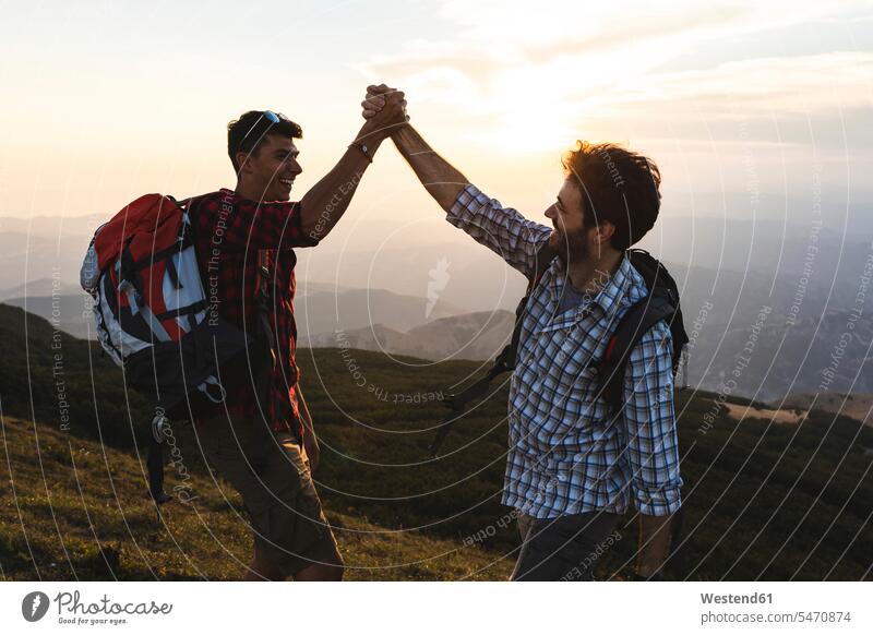 Italien, Monte Nerone, zwei glückliche und erfolgreiche Wanderer in den Bergen bei Sonnenuntergang Glück glücklich sein glücklichsein Gebirge Berglandschaft