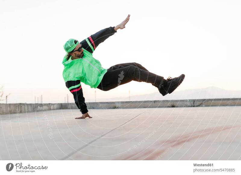 Mann macht Breakdance in städtischem Betongebäude, stehend auf Hand Kunststück Trick sportlich Breakdancing Mann mittleren Alters Männer mittleren Alters tanzen