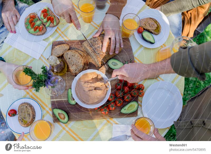 Nahaufnahme von Freunden, die ein gesundes veganes Frühstück im Freien genießen Leute Menschen People Person Personen Europäisch Kaukasier kaukasisch