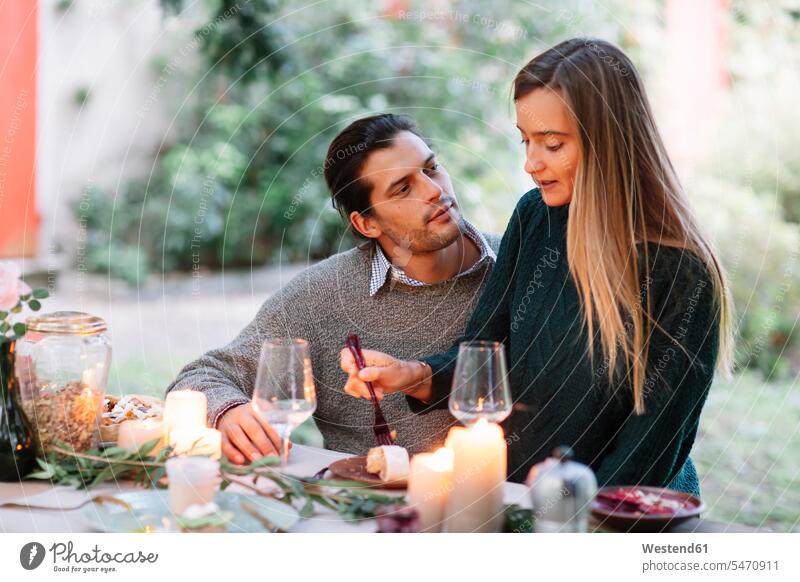 Romantisches Paar mit Kerzenlicht Mahlzeit am Gartentisch romantisch schwärmerisch schwaermerisch gefuehlvoll gefühlvoll Romantik essen essend Mahlzeiten Essen