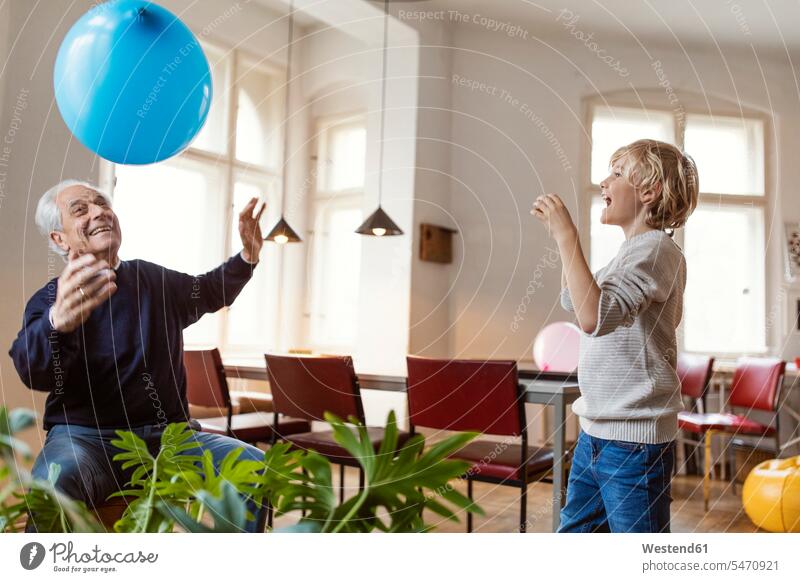 Glücklicher Großvater und Enkel spielen zu Hause mit dem Ballon Generation Ballons Luftballone Luftballons fliegend begeistert Enthusiasmus enthusiastisch