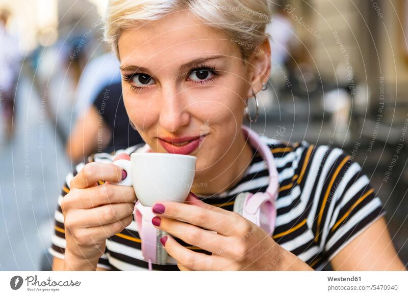 Porträt einer lächelnden jungen Frau, die einen Espresso in einem Straßencafé trinkt Expresso Straßencafe Straßencafes Strassencafe Strassencafes trinken