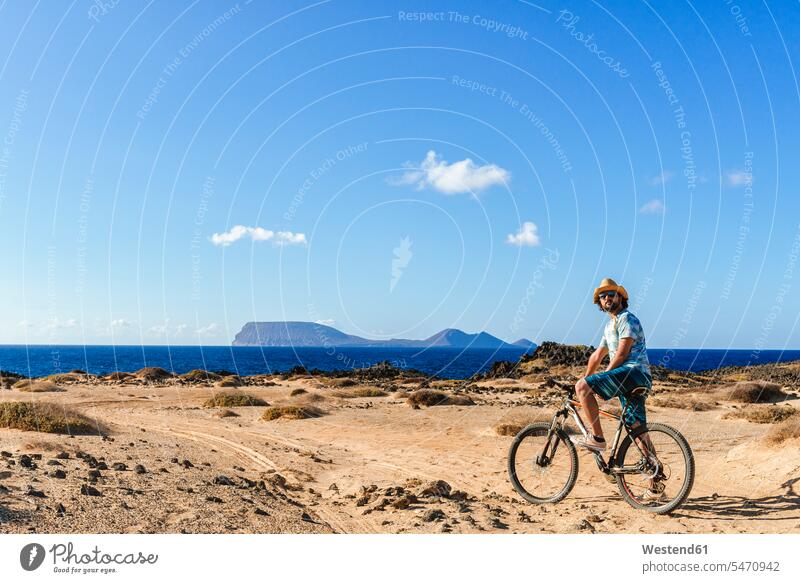 Mann auf einem Fahrrad, La Graciosa Insel, Lanzarote, Kanarische Inseln, Spanien Leute Menschen People Person Personen Europäisch Kaukasier kaukasisch 1 Ein