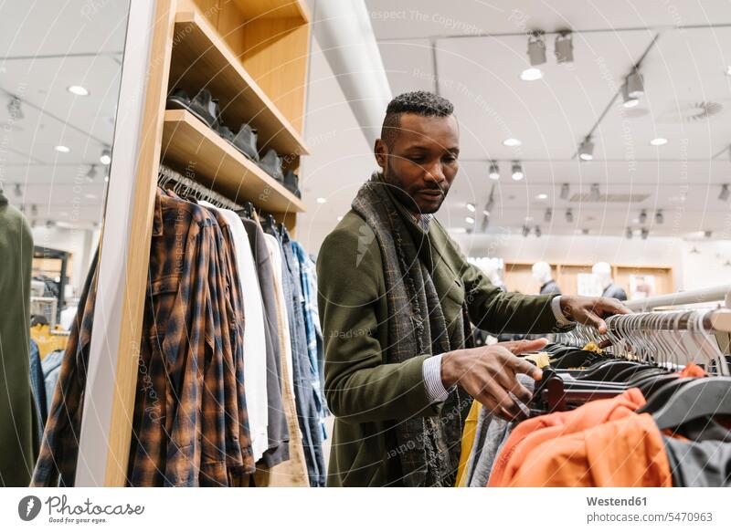 Stilvoller Mann beim Einkaufen in einem Bekleidungsgeschäft Leute Menschen People Person Personen Kunden Kundschaft geschäftlich Geschäftsleben Geschäftswelt