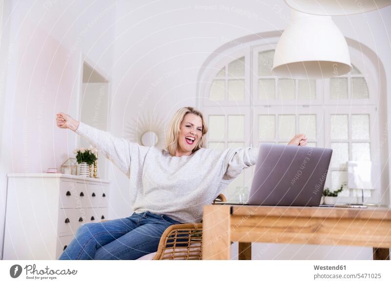 Porträt einer glücklichen blonden reifen Frau mit Laptop zu Hause weiblich Frauen blonde Haare blondes Haar Glück glücklich sein glücklichsein Portrait Porträts