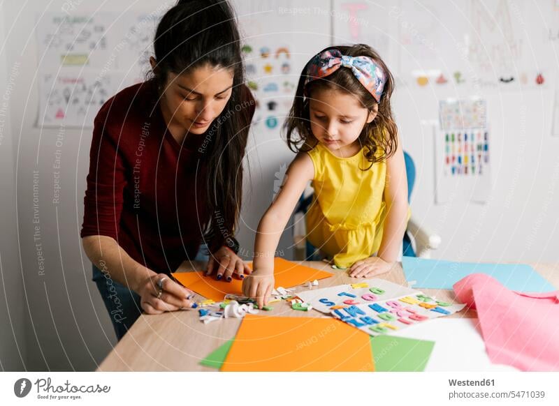 Mutter und Tochter basteln zu Hause Tische Papiere Bastelarbeit Basteleien farbig mehrfarbig daheim Muße Miteinander Zusammen Eingebung Ideen Kreativ Bindung