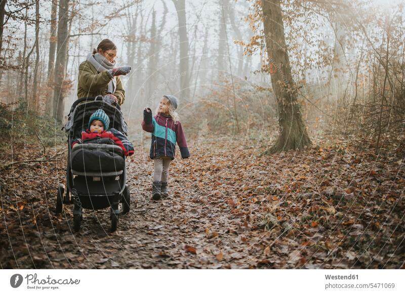 Mutter mit Töchtern beim Waldspaziergang im Herbst Mützen winterlich Winterzeit Muße Miteinander Zusammen auf Achse in Bewegung Travel Ausfluege Ausflüge