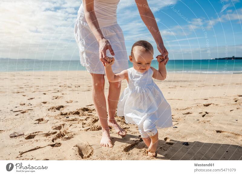 Mutter hilft kleiner Tochter beim Strandspaziergang helfen mithelfen Hilfsbereitschaft beistehen Mithilfe Beistand Hilfe Mami Mutti Mütter Mama Töchter Baby