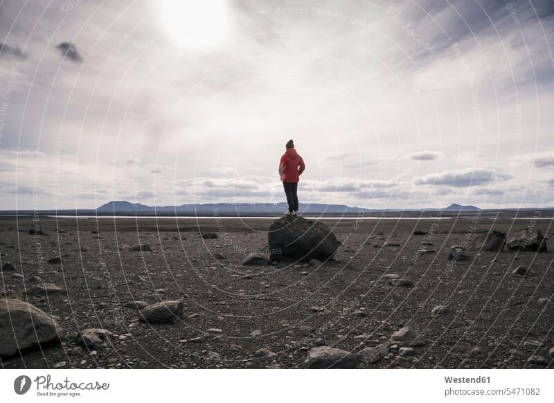 Reifer Mann steht auf einem Felsen im vulkanischen Hochland von Island Jacken ausgeglichen Ausgeglichenheit Gleichgewicht Balance stehend frei auf Achse
