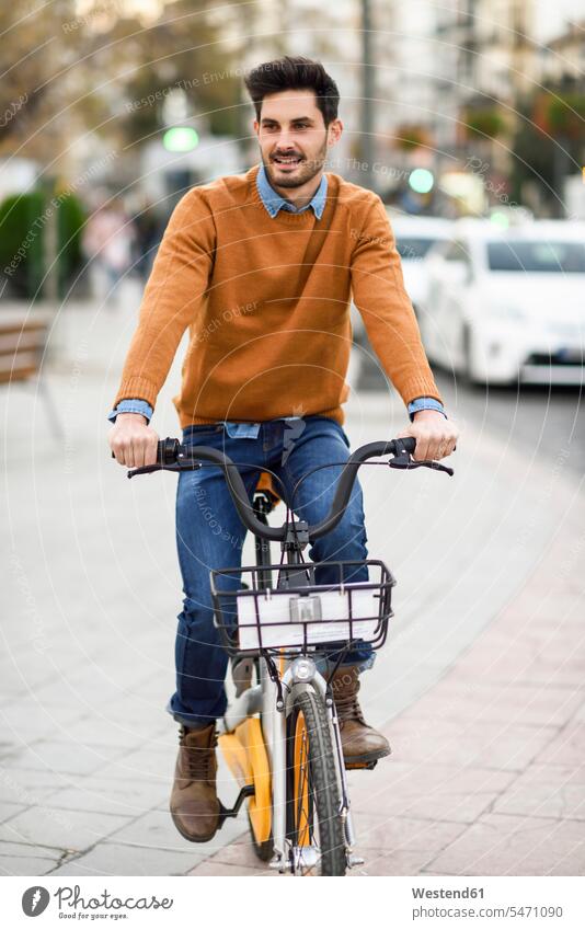 Porträt eines jungen Mannes auf einem Mietfahrrad in der Stadt Stadtfahrrad Citybike Fahrrad Bikes Fahrräder Räder Rad fahren fahrend fahrender fahrendes