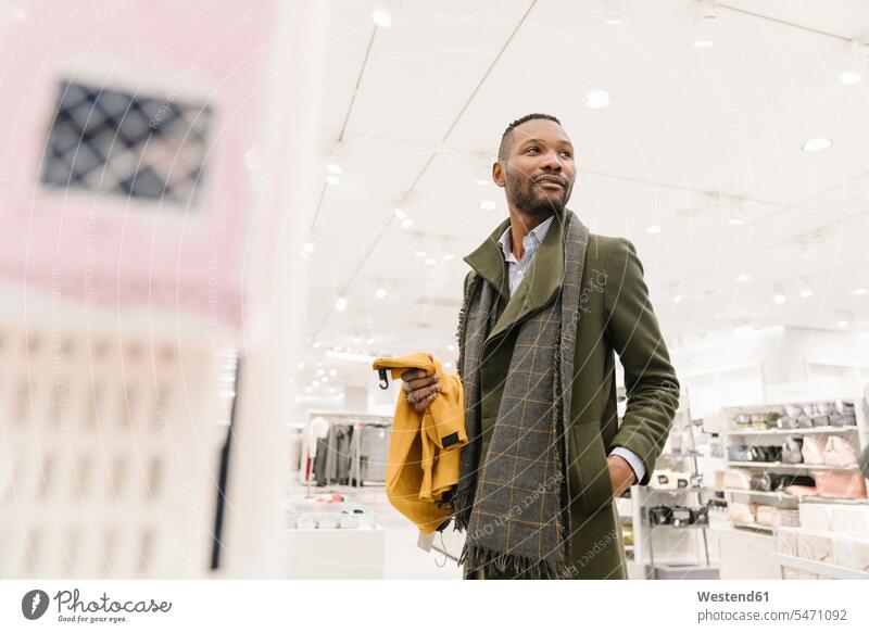 Stilvoller Mann beim Einkaufen in einem Bekleidungsgeschäft Leute Menschen People Person Personen Kunden Kundschaft geschäftlich Geschäftsleben Geschäftswelt