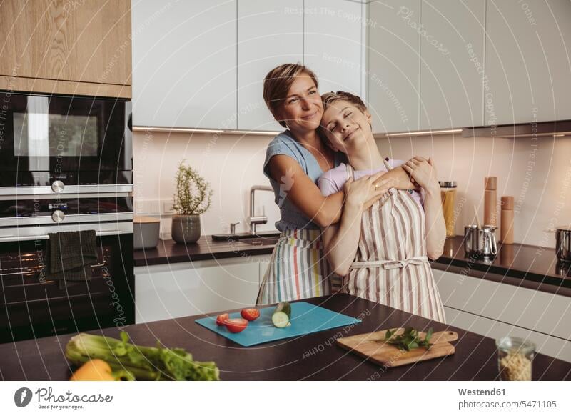 Glückliche lesbische Paar steht in der Küche mit Schürzen stehen stehend Pärchen Paare Partnerschaft glücklich glücklich sein glücklichsein Mensch Menschen