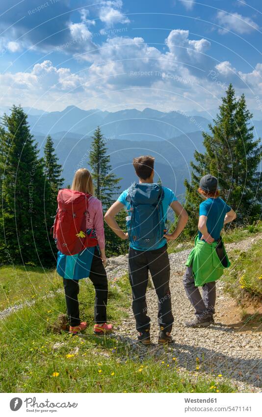 Deutschland, Bayern, Brauneck bei Lenggries, junge Freunde stehen in alpiner Landschaft und betrachten die Aussicht Gebirge Berglandschaft Gebirgslandschaft