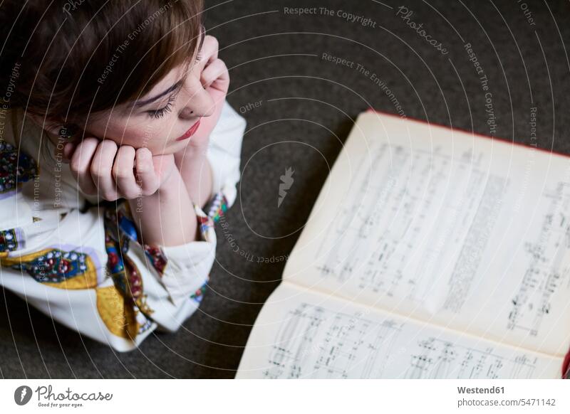Studentin beim Lesen eines Musikbuchs in einer öffentlichen Bibliothek Buch Musikerin Notenbuch Frau liegen Musiknote lesen Akademische Bildung Erwachsener