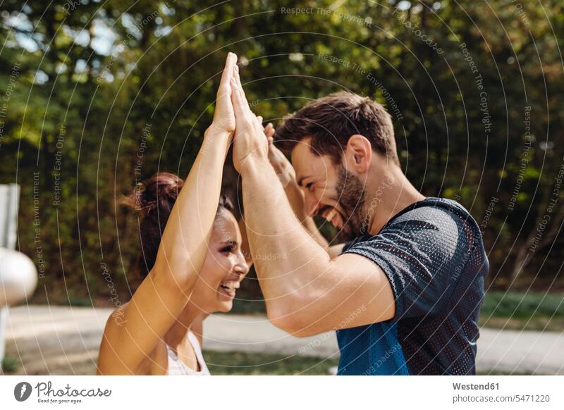 Mann und Frau High-Fiving auf einem Fitness-Parcours Leute Menschen People Person Personen Europäisch Kaukasier kaukasisch gemischtrassig 2 2 Menschen
