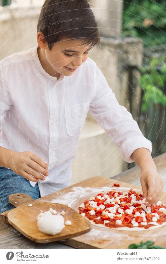 Junge beim Zubereiten von Pizza Hemden freuen Glück glücklich sein glücklichsein zufrieden daheim zu Hause Brauchtum traditionell Essen Essen und Trinken Food