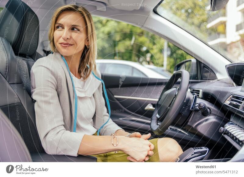 Bildnis einer lächelnden Frau mit Schutzmaske im Auto sitzend KFZ Verkehrsmittel Automobil Autos PKW PKWs Wagen fahrend fahrende fahrender fahrendes freuen