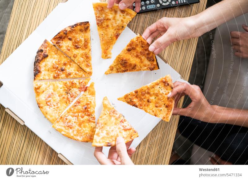 Freunde essen Pizza aus einer Schachtel, nehmen Stücke Spanien Stueck Stuecke Hand Hände essend Mittagessen Lunch Mensch Menschen Leute People Personen Mahlzeit