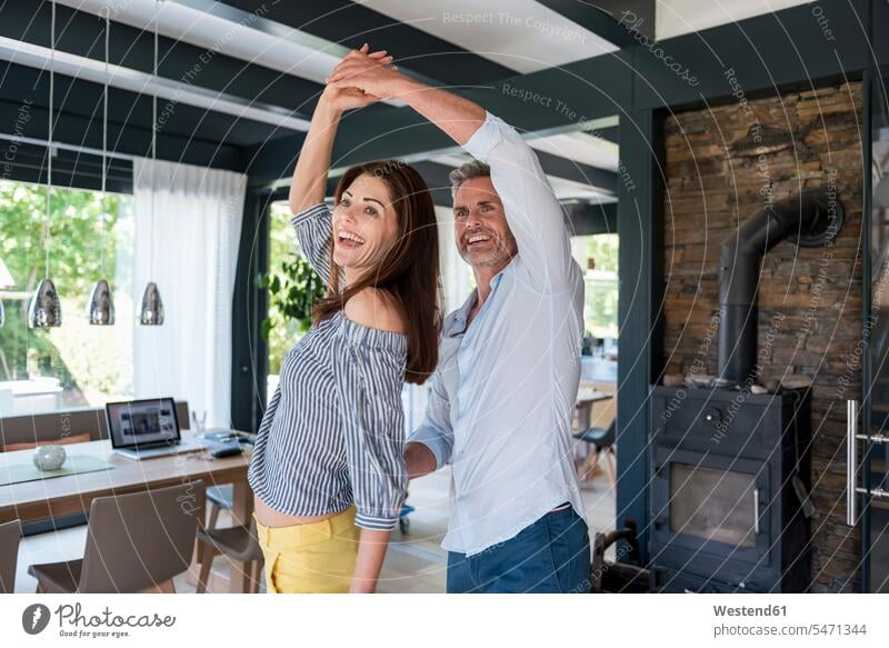 Glückliches Paar tanzt zu Hause Pärchen Paare Partnerschaft Zuhause daheim tanzen tanzend lächeln glücklich glücklich sein glücklichsein Mensch Menschen Leute