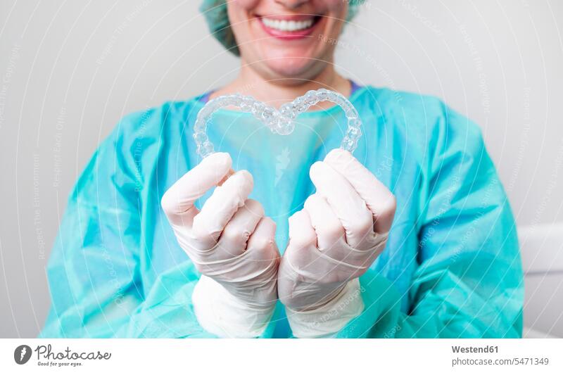 Nahaufnahme einer Krankenschwester, die in der Klinik Dental Aligner in Herzform hält Farbaufnahme Farbe Farbfoto Farbphoto Innenaufnahme Innenaufnahmen innen