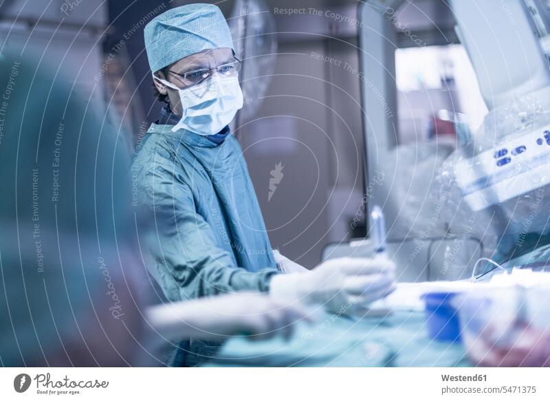Neuroradiologe im Kittel mit Spritze Arzt Doktoren Ärzte Krankenhaus Kliniken Krankenhäuser Krankenhaeuser Operation OP Operationen operieren Chirurgie