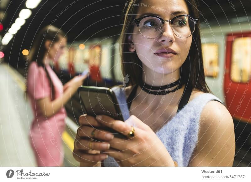 Teenager-Mädchen benutzt Handy in U-Bahn-Station Ubahn U-Bahnen Untergrundbahnen Ubahnen Underground Subway Frau weiblich Frauen Mobiltelefon Handies Handys