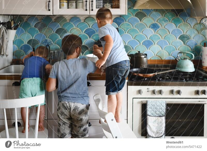Drei Brüder kochen Pfannkuchen in der Küche Leute Menschen People Person Personen Europäisch Kaukasier kaukasisch Gruppe von Menschen Menschengruppe