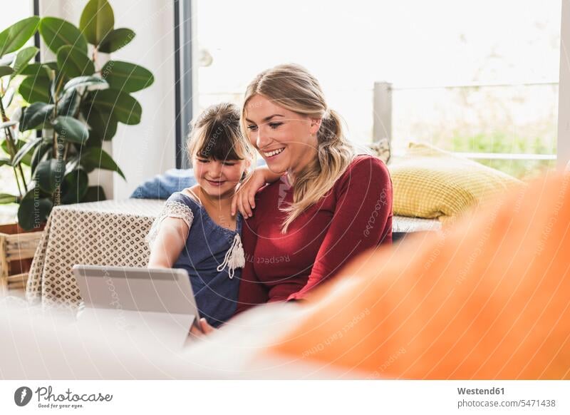 Glückliche Mutter und Tochter verwenden Tablet zu Hause Medium Videofilm Videos sitzend sitzt entspannen relaxen entspanntheit relaxt freuen Frohsinn