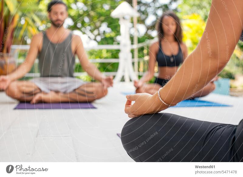 Zwei Frauen und ein Mann praktizieren Yoga auf der Terrasse üben ausüben Übung trainieren Yoga-Übungen Yogauebungen Yogaübungen Jogauebung Jogauebungen