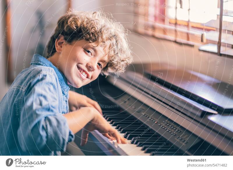 Porträt eines lächelnden Jungen, der zu Hause Klavier spielt Leute Menschen People Person Personen Europäisch Kaukasier kaukasisch Südeuropäisch 1 Ein