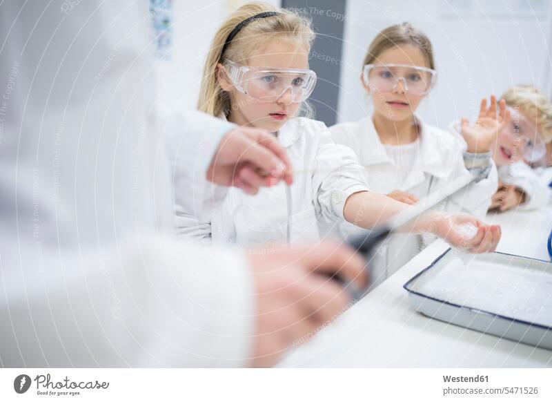 Schülerinnen und Schüler im naturwissenschaftlichen Unterricht beobachten Lehrer beim Experimentieren Mitschüler Schule zusehen Naturwissenschaftskurs Versuch