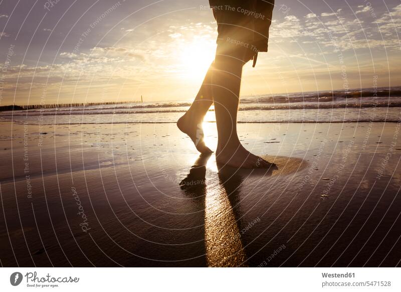 Niederlande, Cadzand-Bad, Beine eines Teenagers, der in der Dämmerung am Strand spazieren geht männlicher Teenager männlicher Jugendlicher männliche Jugendliche