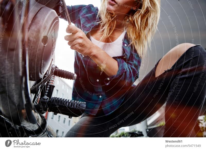 Junge Frau arbeitet am Motorrad Motorräder arbeiten Arbeit weiblich Frauen Kraftfahrzeug Verkehrsmittel KFZ Verkehrswesen Transportwesen Erwachsener erwachsen