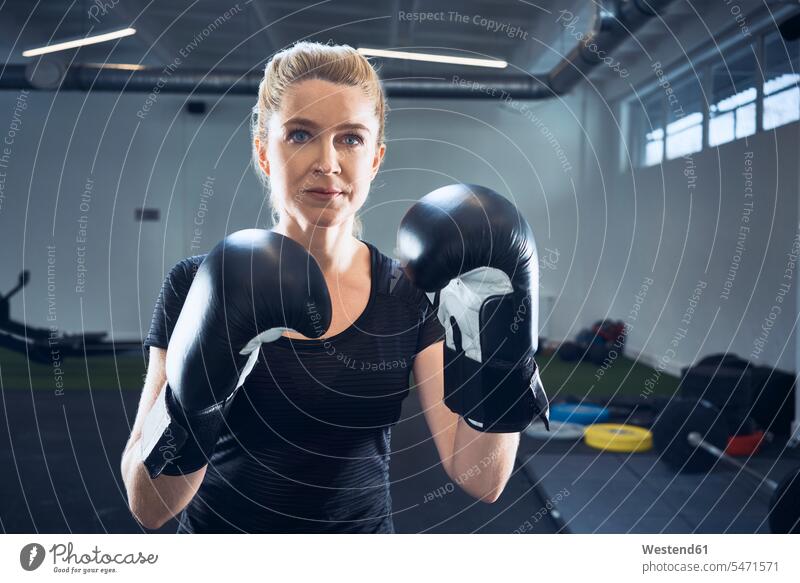 Porträt einer Frau, die im Fitnessstudio Boxen übt Portrait Porträts Portraits Training trainieren Fitnessclubs Fitnessstudios Turnhalle boxen Kampfsport