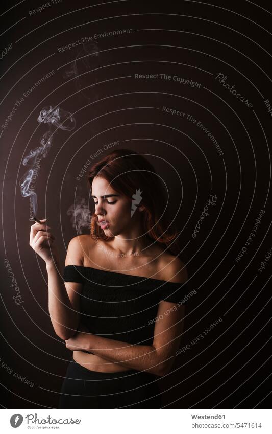 Junge Frau raucht Marihuana zu Hause Tabak Zigaretten sitzend sitzt abends entspannen relaxen entspanntheit relaxt geniessen Genuss daheim Realitätsflucht