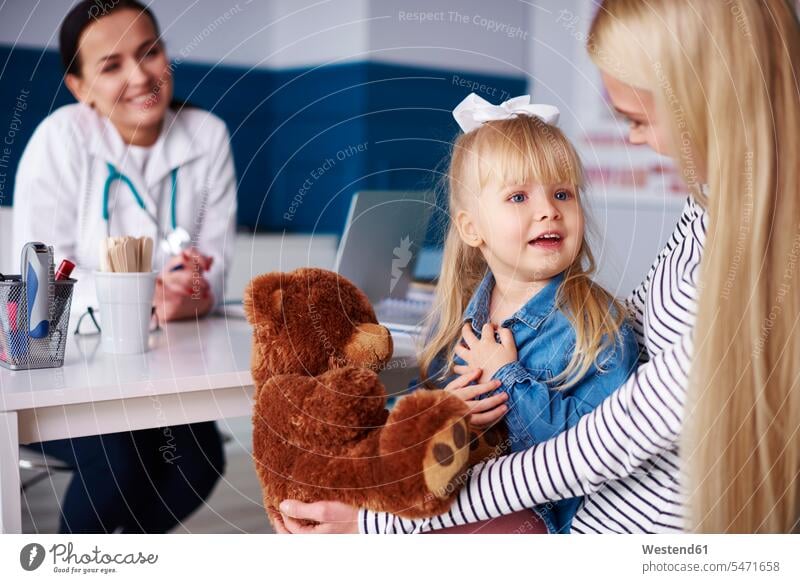 Mutter mit Mädchen und Teddy in medizinischer Praxis Mami Mutti Mütter Mama Teddies weiblich Arztpraxis Arztpraxen Ärztin Aerztin Ärztinnen Doktorinnen