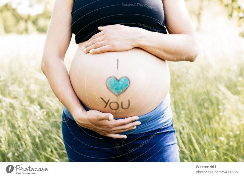 Junge schwangere Frau hält Babybauch, ich liebe dich Oberkoerper Oberkörper Torso Torsos Bäuche anfassen Berührung gefühlvoll Emotionen Empfindung Empfindungen