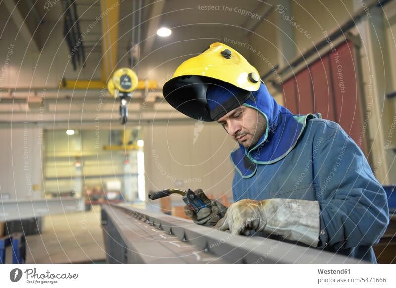Schweißer prüft Metalloberfläche in der Fabrik Fabriken arbeiten Arbeit prüfen Kontrolle Untersuchung kontrollieren pruefen Oberfläche Oberflaeche Schweisser