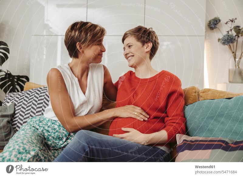 Glückliches lesbisches Paar berührt den Bauch der werdenden Mutter schwanger Schwangere schwangere Frau Pärchen Paare Partnerschaft glücklich glücklich sein