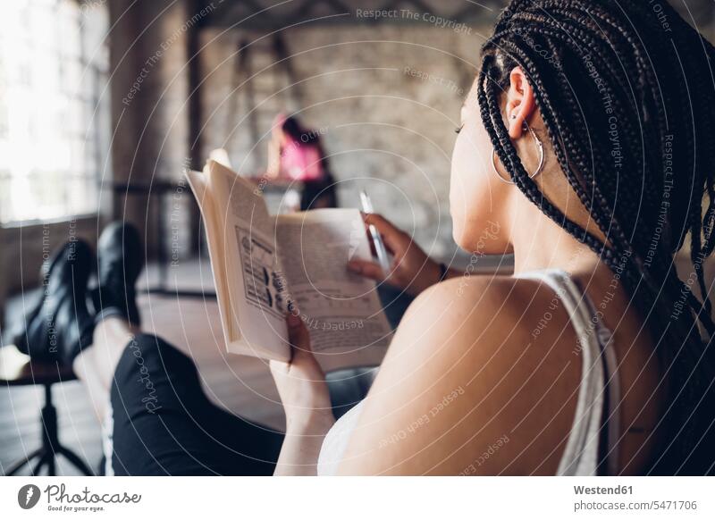 Junge Frau liest ein Buch im Loft-Büro Job Berufe Berufstätigkeit Beschäftigung Jobs geschäftlich Geschäftsleben Geschäftswelt Geschäftsperson Geschäftspersonen