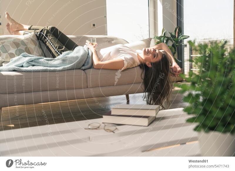 Entspannte junge Frau auf Couch liegend Deutschland Wohnung wohnen Wohnungen Auszeit Alles hinter sich lassen abschalten entspannen Wohlbefinden Lifestyle