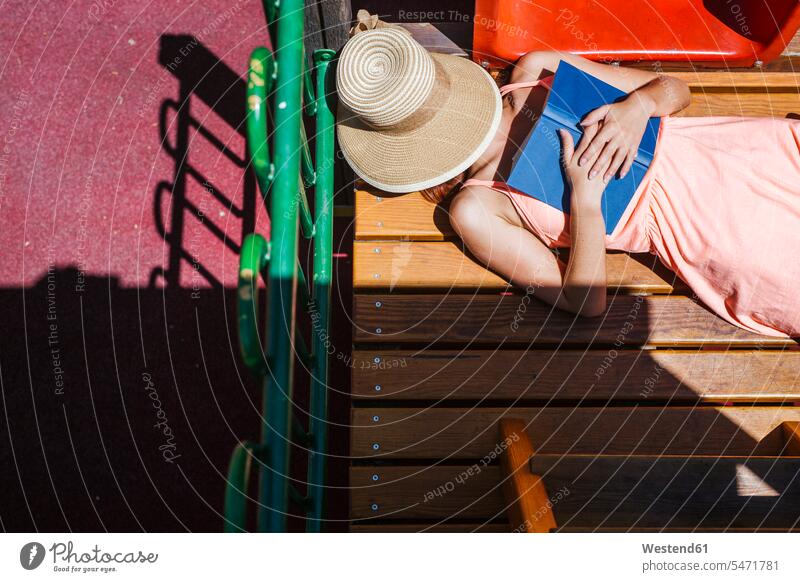 Frau mit Buch beim Ausruhen Bücher entspannen relaxen Lektüre sommerlich Sommerzeit Farben Farbtoene Farbton Farbtöne rosafarben Muße Travel Ferien sonnig außen