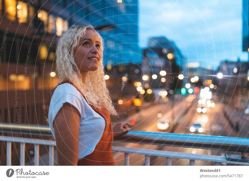 Junge Frau in der Stadt in der Dämmerung mit städtischer Straße in London abends freuen Glück glücklich sein glücklichsein zufrieden frei Eingebung Ideen Muße