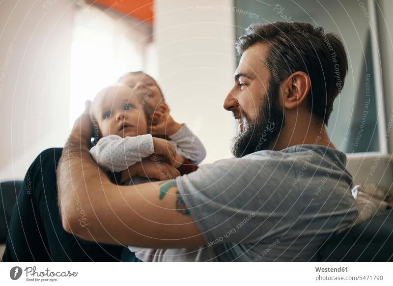 Glücklicher Vater mit Mädchen und kleinem Sohn zusammen zu Hause Papas Väter Vati Vatis Papis weibliche Babys weibliches Baby weibliche Babies glücklich