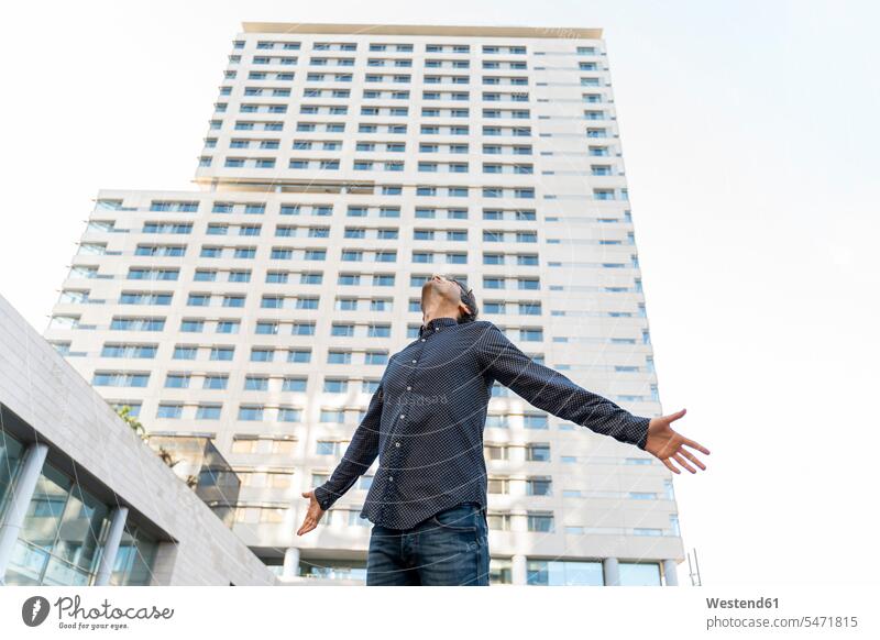 Geschäftsmann vor einem Hochhaus in der Stadt mit Blick nach oben, Barcelona, Spanien Leute Menschen People Person Personen Europäisch Kaukasier kaukasisch