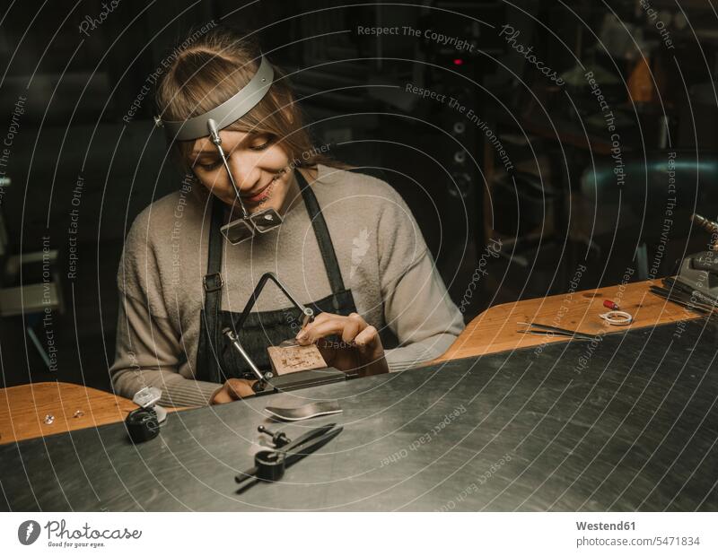 Kunsthandwerker bei der Herstellung von Schmuck in seiner Werkstatt Europäer Kaukasier Europäisch kaukasisch Anfertigung anfertigen sitzen sitzend sitzt