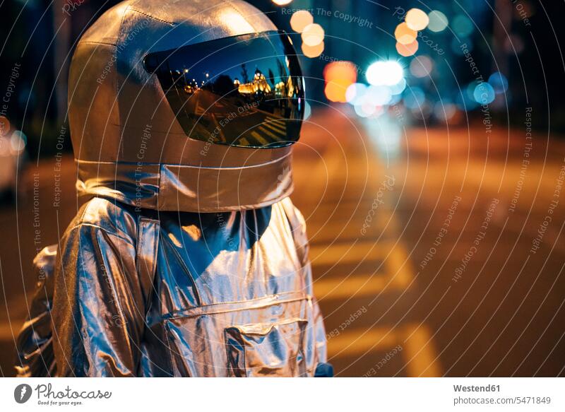 Spaceman auf einer Straße in der Stadt bei Nacht Strassen Straßen Raumfahrer Weltraumfahrer staedtisch städtisch Astronaut Astronauten nachts Raumfahrt Verkehr