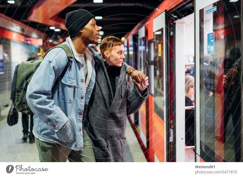 Junges Paar am Bahnsteig beim Betreten der U-Bahn Leute Menschen People Person Personen erwachsen Erwachsene Frauen weiblich jung junge Frauen Afrikanisch