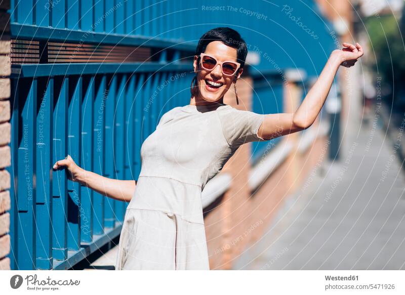 Glückliche modische junge Frau trägt Kleid und Sonnenbrille Spanien Schönheit Beauty Lifestyle Lebensstil Agil Gewandtheit behaende gewandt Agilität Agilitaet